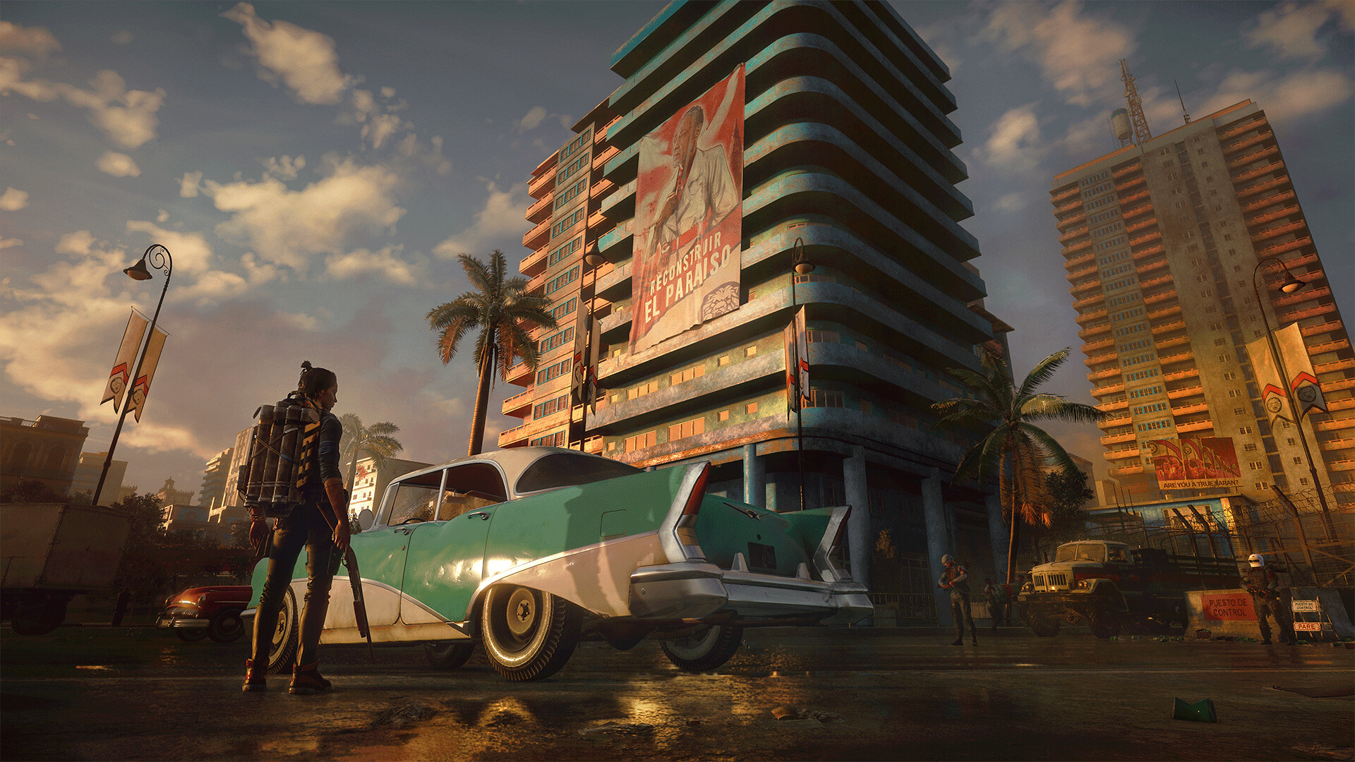 Far Cry 6: a Yaran street at sunset with a vintage car and FND propaganda banners